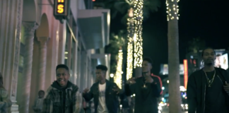 Adrian Junior FT. Boogie Fre$h "City Lights" Screen Shot Men walking boulevard with shops and lighted palm trees