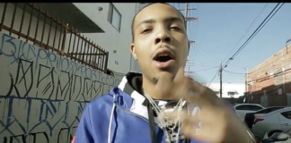 G Herbo "Focused" Video Screen Shot of G Herbo wearing a blue hoodie and silver chains with a Graffiti Wall backdrop